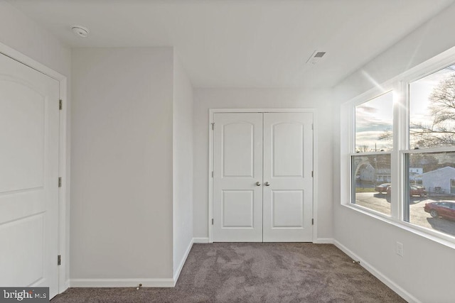 interior space featuring visible vents, baseboards, a closet, and carpet floors