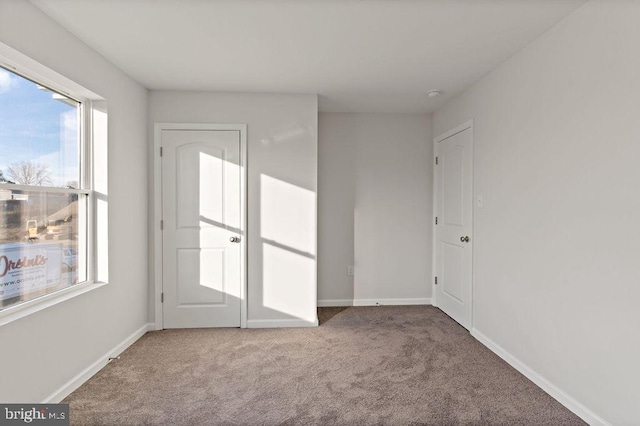 carpeted spare room featuring baseboards