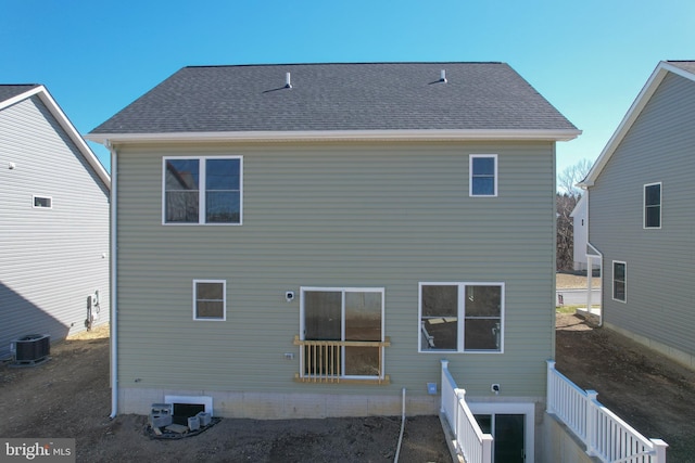 back of property featuring cooling unit and roof with shingles