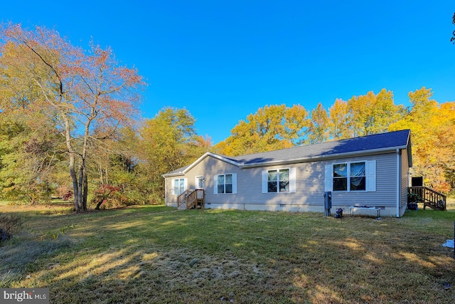 rear view of property with a yard