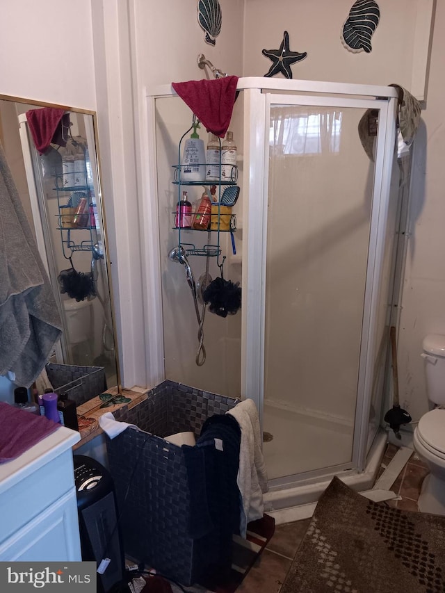 bathroom with walk in shower, tile patterned flooring, and toilet