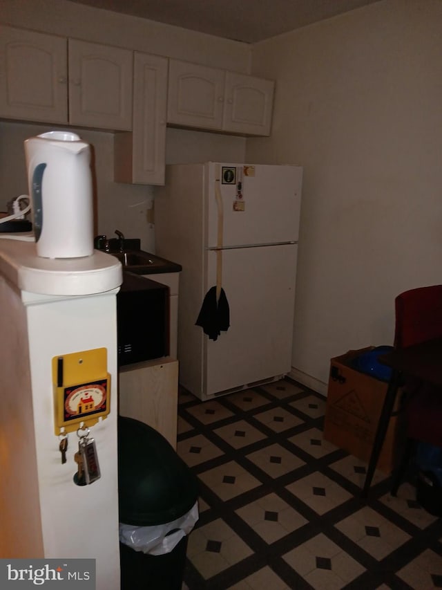 kitchen with white cabinets and white fridge