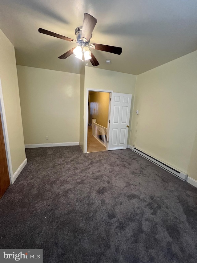 unfurnished room featuring ceiling fan, dark colored carpet, and a baseboard heating unit