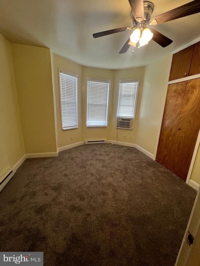 unfurnished bedroom with baseboard heating, dark carpet, ceiling fan, and cooling unit