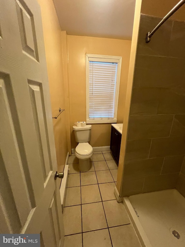 bathroom with tile patterned flooring, vanity, toilet, and walk in shower