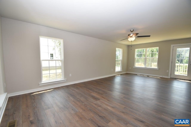 unfurnished room with dark hardwood / wood-style floors, a wealth of natural light, and ceiling fan