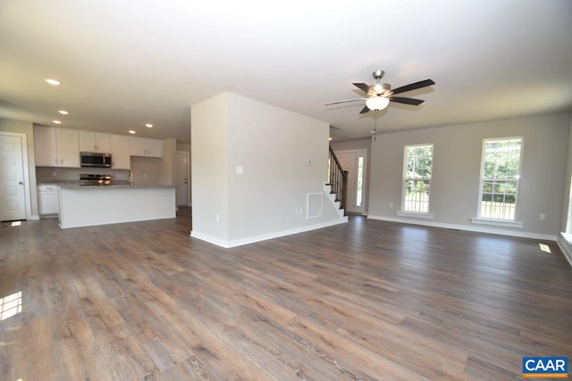 unfurnished living room featuring hardwood / wood-style flooring and ceiling fan