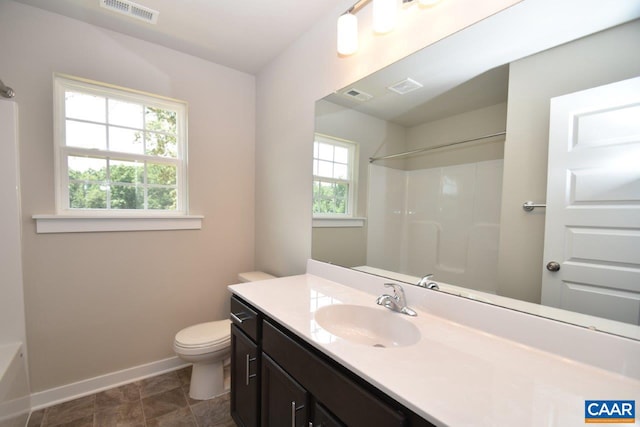 bathroom featuring vanity, toilet, and walk in shower