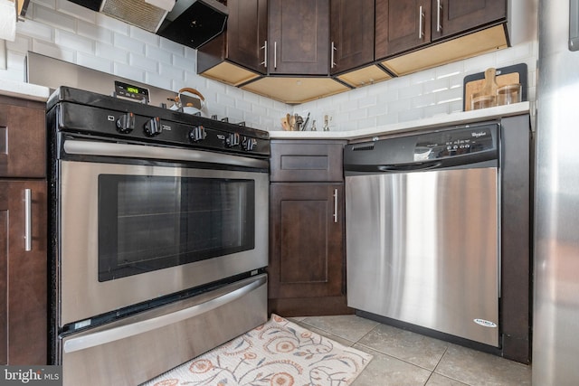 kitchen with stainless steel appliances, dark brown cabinets, backsplash, and light tile patterned floors