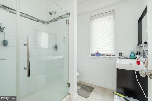 bathroom with toilet, an enclosed shower, a healthy amount of sunlight, and vanity