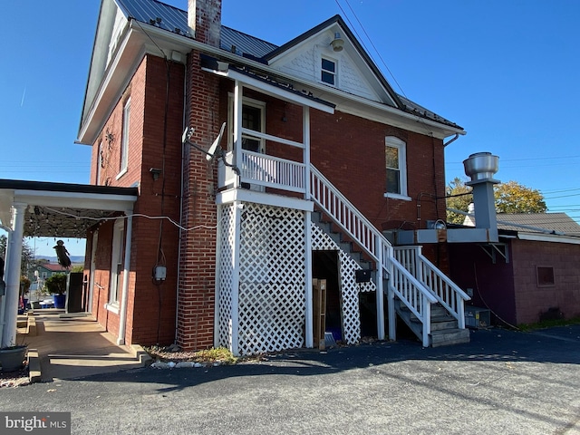 back of house featuring a carport