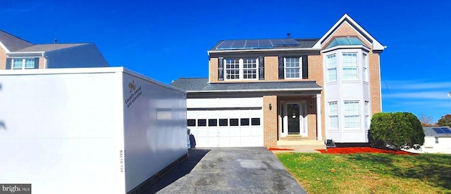 view of front facade featuring solar panels and a front lawn