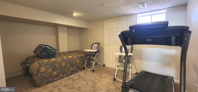 workout area with light carpet and a textured ceiling