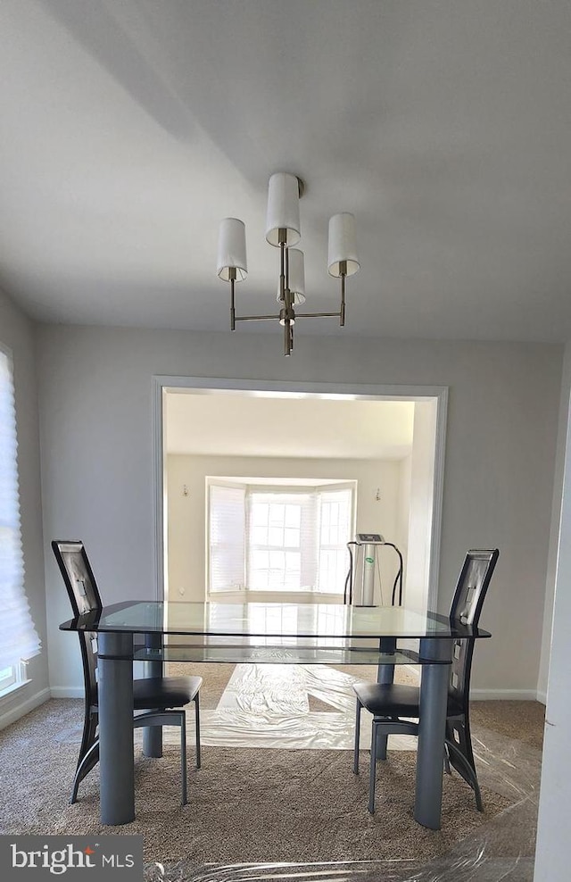 dining space featuring a chandelier and carpet