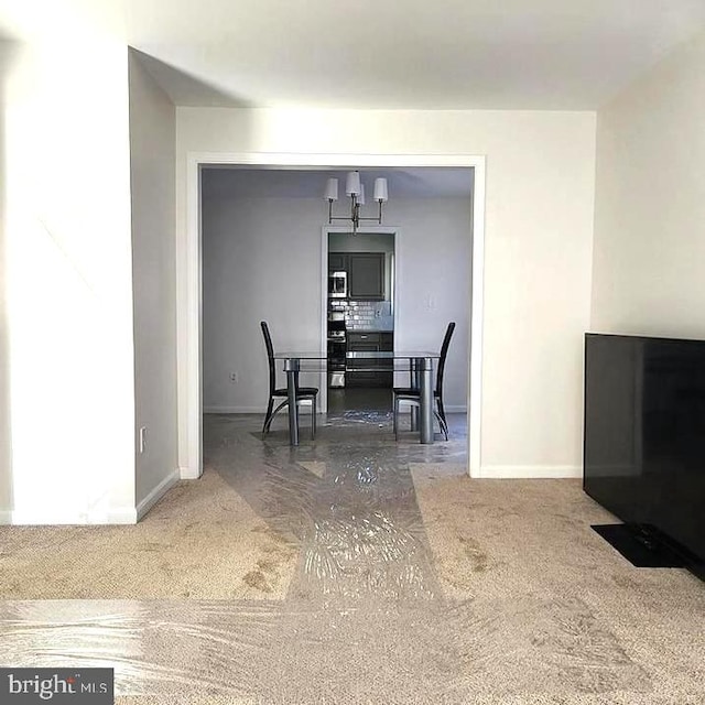 dining space featuring an inviting chandelier and dark colored carpet