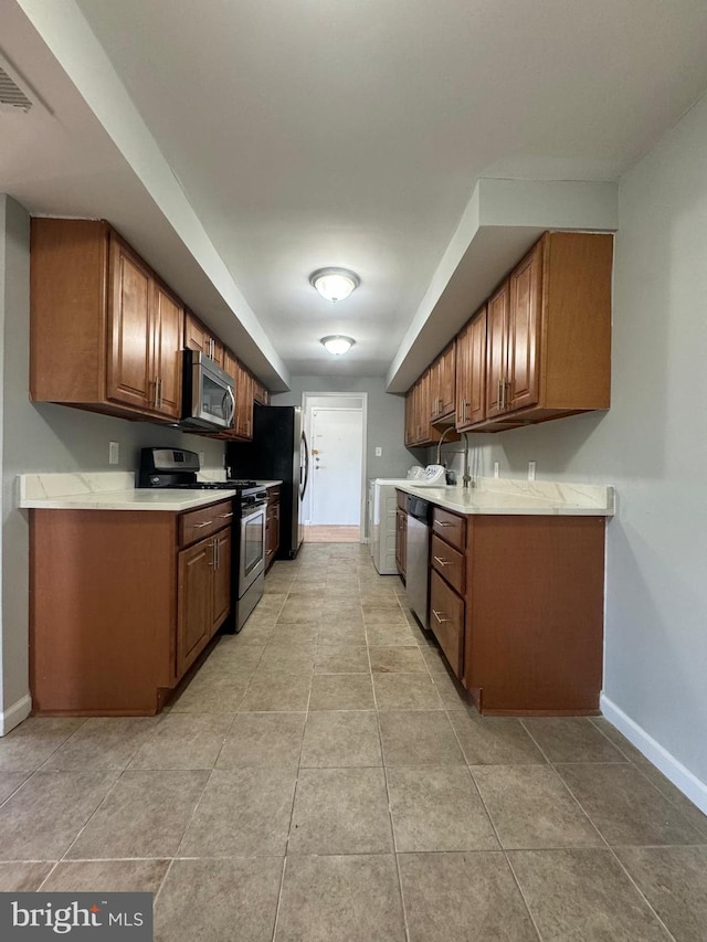 kitchen featuring sink, stainless steel appliances, and light tile patterned floors