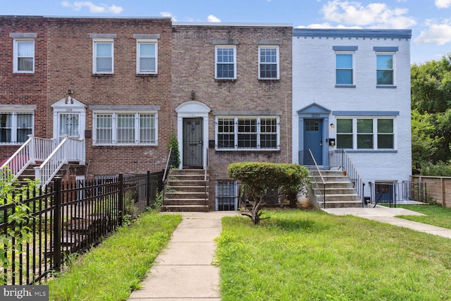 townhome / multi-family property featuring a front lawn