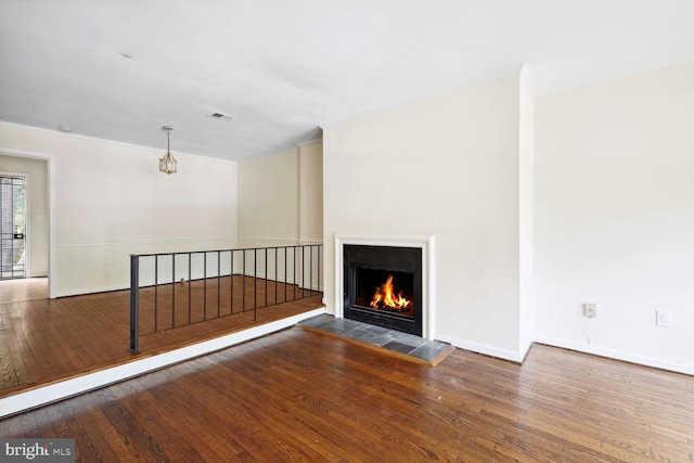 unfurnished living room with hardwood / wood-style flooring and a tiled fireplace