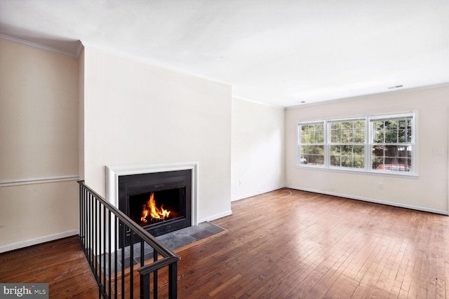 unfurnished living room with ornamental molding and dark hardwood / wood-style flooring