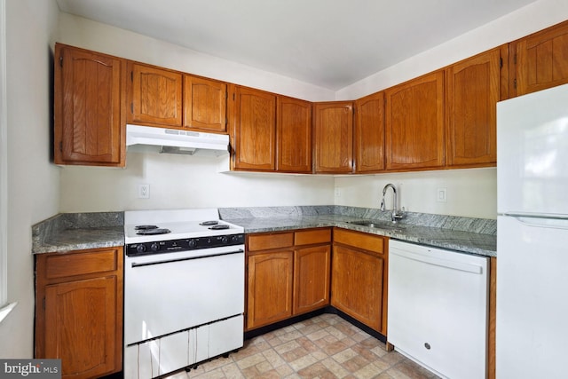 kitchen with sink, stone countertops, and white appliances