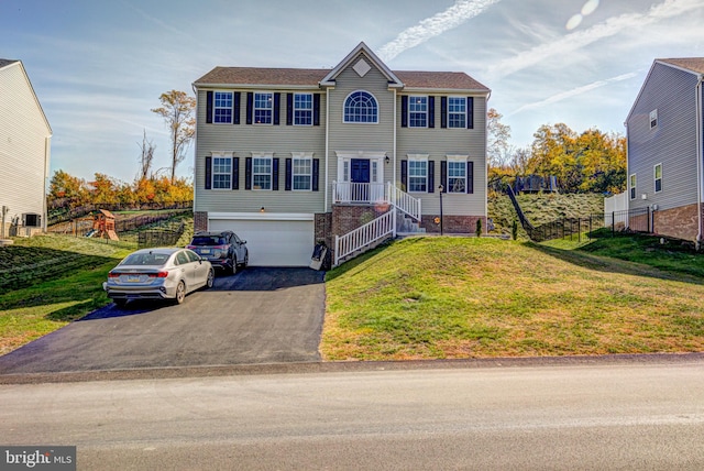 colonial house featuring a front lawn and a garage