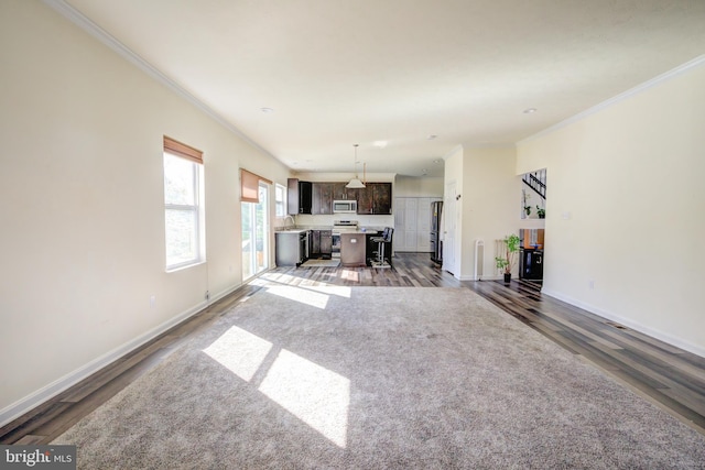 unfurnished living room featuring ornamental molding and dark hardwood / wood-style flooring