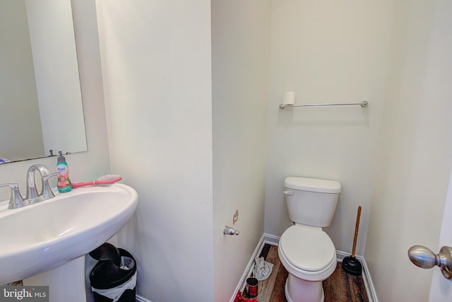 bathroom with toilet, hardwood / wood-style flooring, and sink