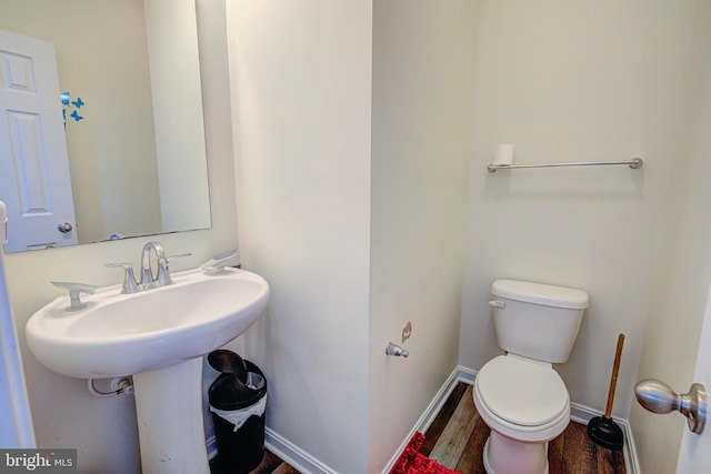 bathroom with toilet and hardwood / wood-style flooring