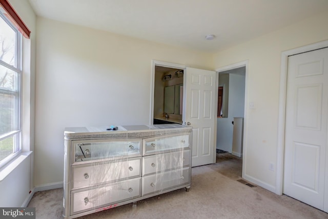 bedroom featuring multiple windows and light colored carpet