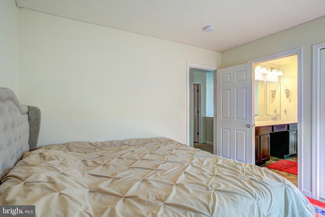 bedroom featuring ensuite bath and sink