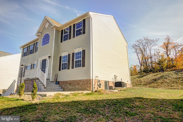 view of front of property featuring cooling unit and a front yard