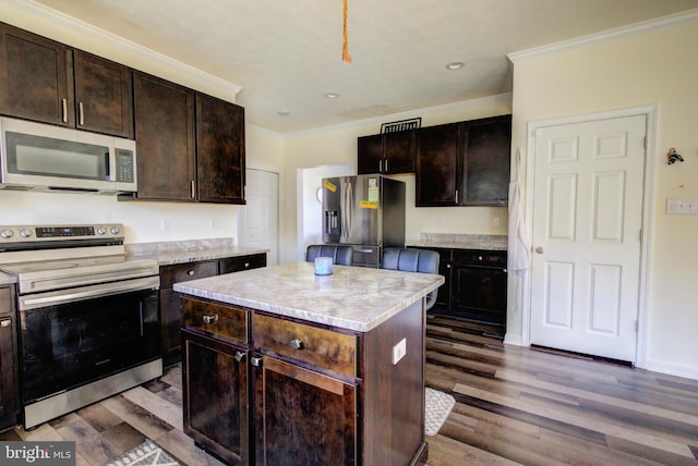 kitchen with dark brown cabinetry, appliances with stainless steel finishes, wood-type flooring, and a kitchen island