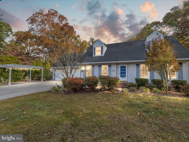 cape cod home featuring a garage, a yard, and a pergola