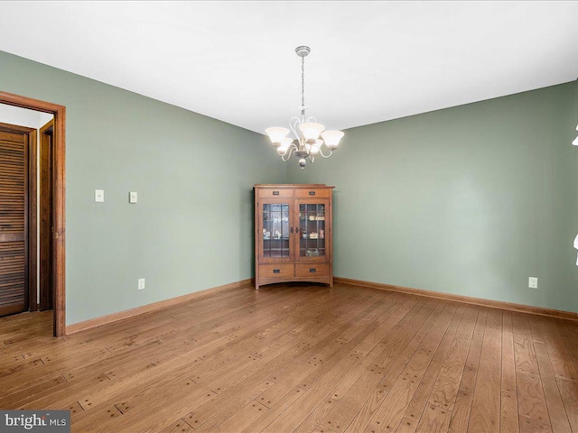 unfurnished dining area featuring light hardwood / wood-style floors and a chandelier