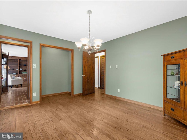 interior space with a notable chandelier and light hardwood / wood-style flooring