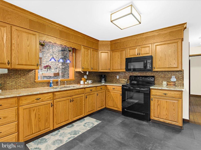 kitchen with light stone counters, decorative backsplash, black appliances, sink, and dark hardwood / wood-style floors