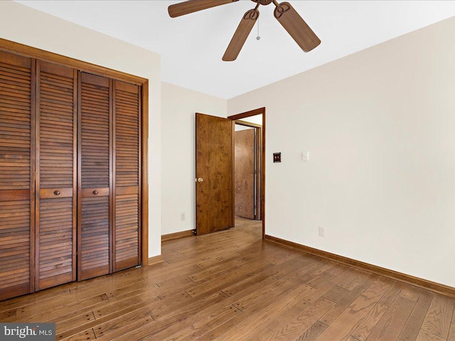 unfurnished bedroom with a closet, hardwood / wood-style floors, and ceiling fan