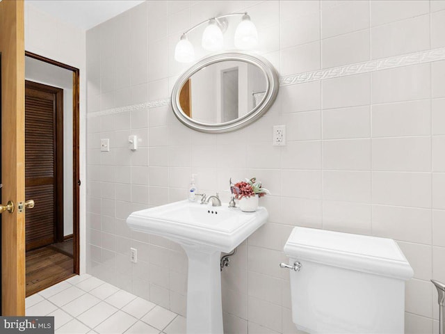 bathroom with hardwood / wood-style floors, toilet, and tile walls