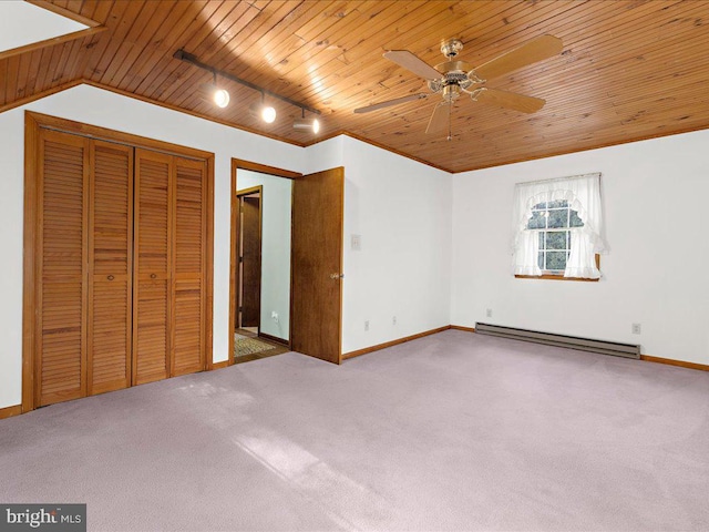 unfurnished bedroom with carpet flooring, a baseboard radiator, and vaulted ceiling