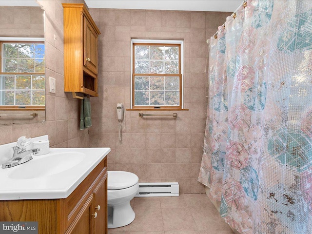 bathroom with baseboard heating, vanity, tile patterned floors, toilet, and tile walls