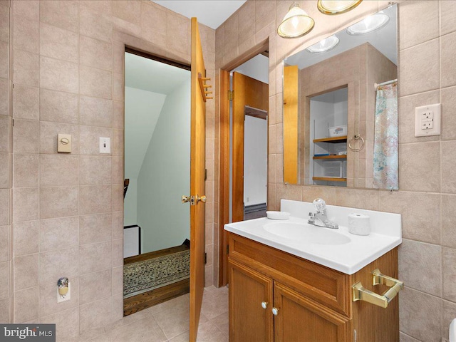 bathroom featuring tile patterned flooring, vanity, and tile walls