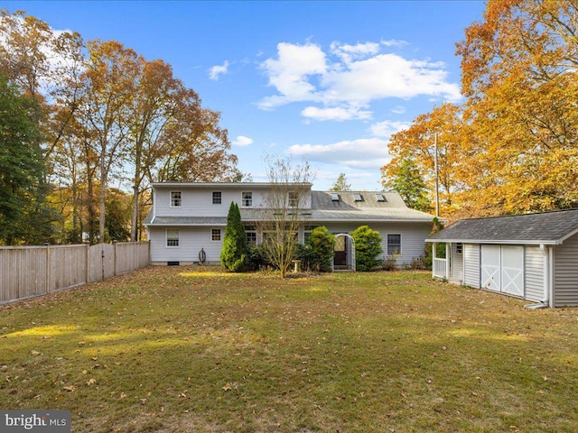 back of property featuring a yard and a storage shed