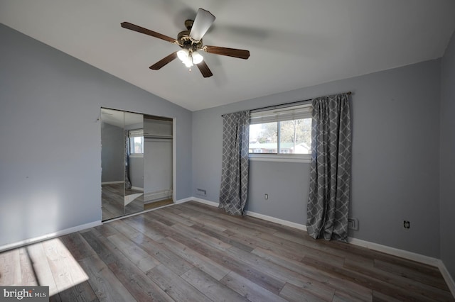 unfurnished bedroom with ceiling fan, a closet, light hardwood / wood-style flooring, and lofted ceiling