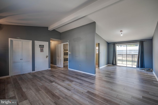 interior space with light hardwood / wood-style floors and lofted ceiling with beams