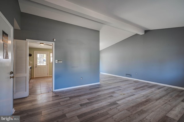 unfurnished room featuring ceiling fan, light hardwood / wood-style flooring, and vaulted ceiling with beams