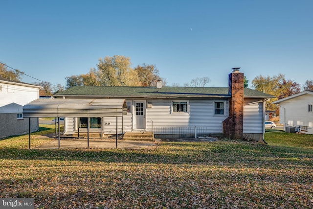 back of property featuring a lawn and central air condition unit