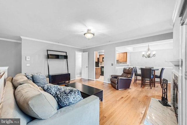 living room featuring hardwood / wood-style flooring, crown molding, and an inviting chandelier