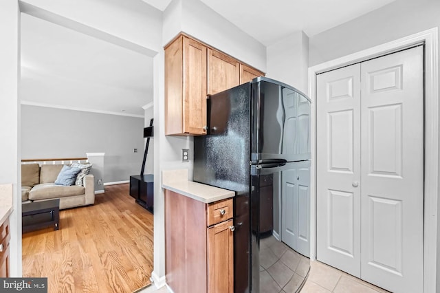 kitchen with light hardwood / wood-style floors and black refrigerator