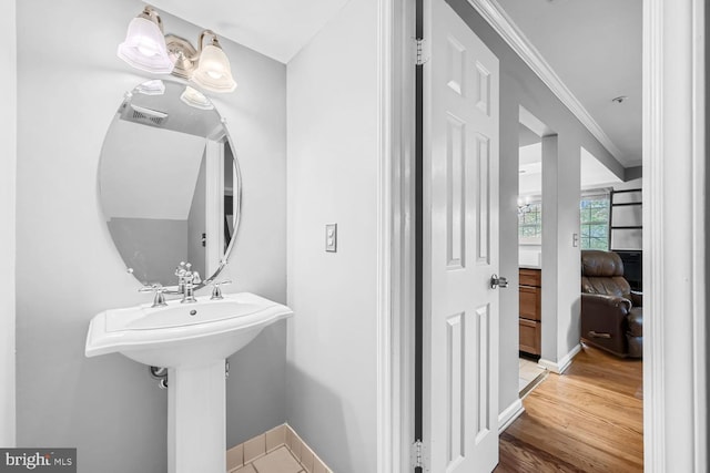 bathroom featuring wood-type flooring and ornamental molding