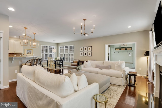 living room with a notable chandelier and dark hardwood / wood-style flooring